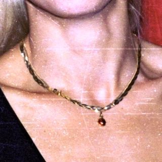 Blonde woman smiling in black top.