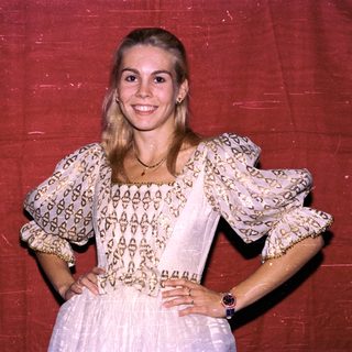Young woman wearing vintage-style patterned blouse and skirt.