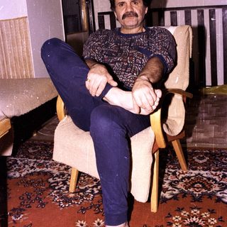 Man sitting relaxed in armchair indoors.