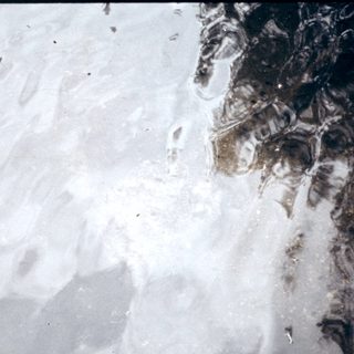 Snow-covered landscape with partially melted areas and visible terrain.