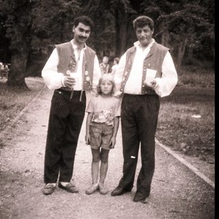 Family portrait in traditional attire outdoors.