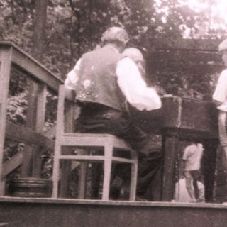 Family gathering at outdoor wooden staircase in forest.