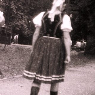 Traditional folk dancers in regional costumes outdoors.