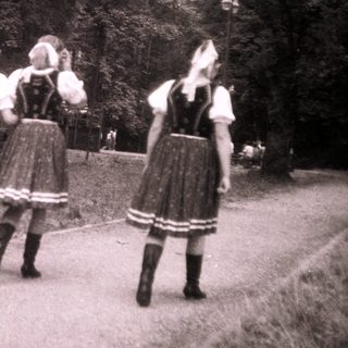Traditional folk dancers in regional costumes outdoors.