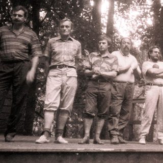 Group of men posing outdoors in casual summer attire.