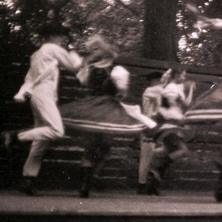 Blurred dancers performing acrobatic moves on rotating chairs.