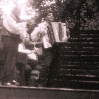 Amateur band playing on elevated platform outdoors.