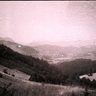 Rural mountainous landscape with valley and distant village.