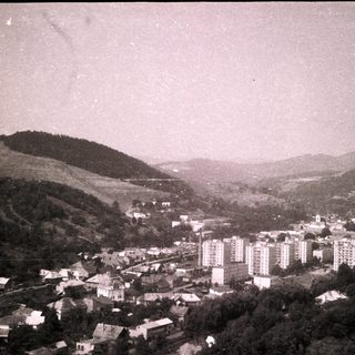 Historic town nestled in hilly landscape with early mid-century buildings.