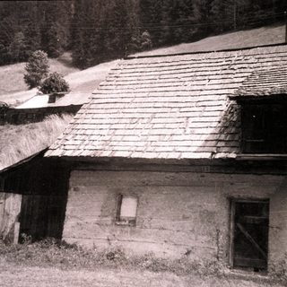 Rural farmhouse with stone walls and tiled roof.