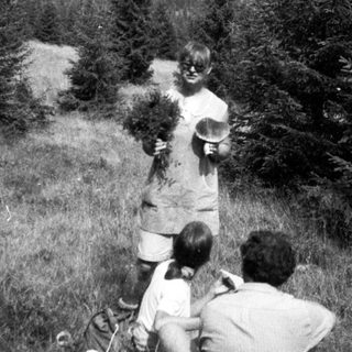 Family hiking with picnic basket in forested area.