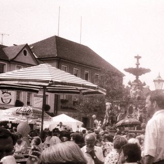 Crowded outdoor market or festival with people and stalls.