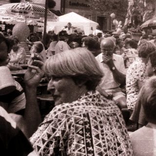 Crowded outdoor market or festival with people and stalls.