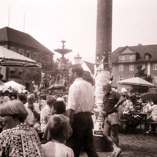 Crowded outdoor market or festival with people and stalls.