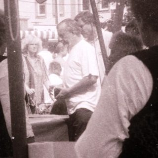 Vintage outdoor market scene with women serving food.