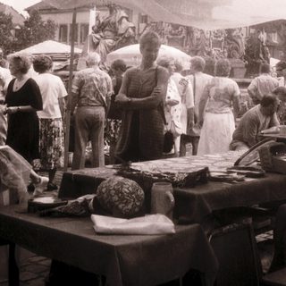 Outdoor market scene with food stalls and people.