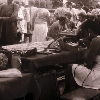 Outdoor market scene with food stalls and people.