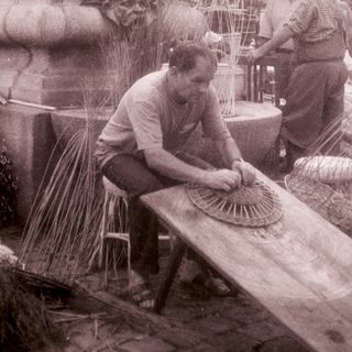 Traditional fan-making demonstration in outdoor setting.