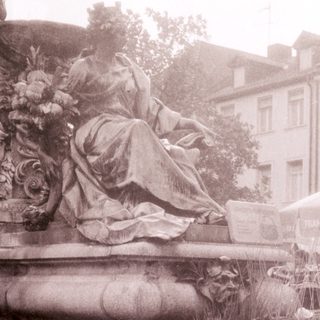 Traditional fan-making demonstration in outdoor setting.