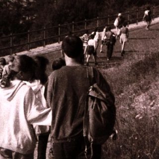 People hiking along scenic lakeside trail.