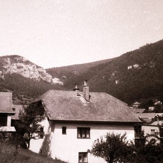 Rural mountain village with houses and rocky hills.