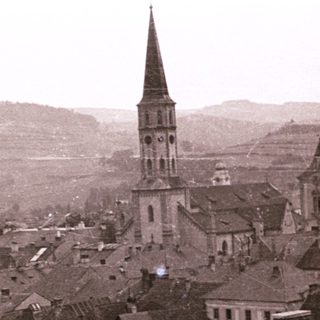Historic town with prominent church spires and sloped rooftops.