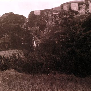 Mountain cliff with cascading waterfall.