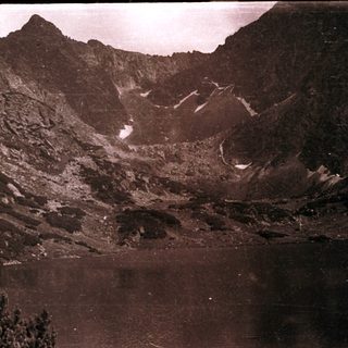 Crater lake surrounded by rugged volcanic terrain.