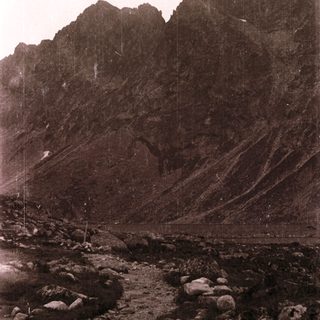 Steep rocky mountain slope with climbing ropes.