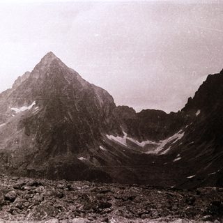 Stark alpine peak with snow patches.