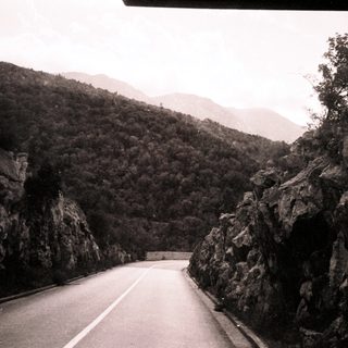 Winding mountain road through forested valley.