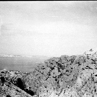 Coastal cliff overlooking vast ocean horizon.