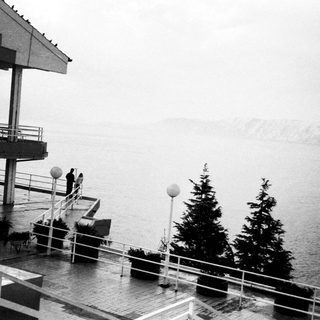 Modern lakeside terrace with foggy waterfront view.