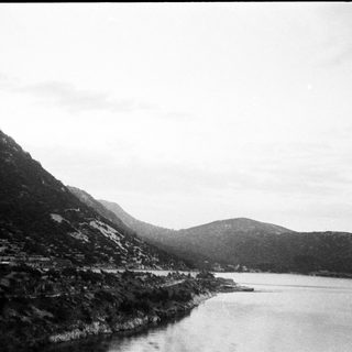Mountainous shoreline with river or lake.