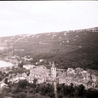 Historic coastal town with church and industrial chimneys.