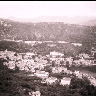 Aerial view of a lakeside village nestled among hills.