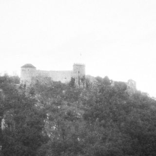 Castle perched atop rugged hillside.