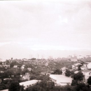 Urban landscape with distant mountains and residential buildings.