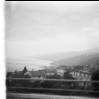 Blurred view of rural landscape with hills and houses.