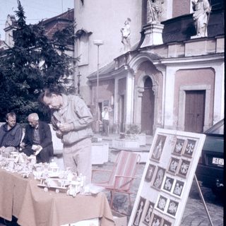Street market stall selling vintage postcards and small items.