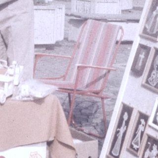 Street market stall selling vintage postcards and small items.