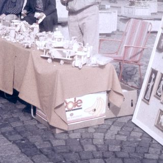 Street market stall selling vintage postcards and small items.