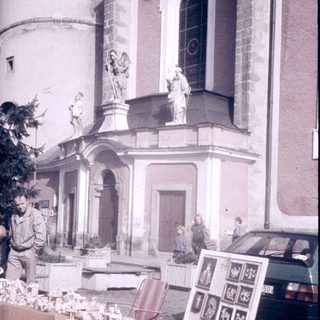 Street market stall selling souvenirs near historic church.