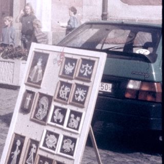 Street market stall selling souvenirs near historic church.