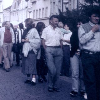 Busy European street scene with pedestrians and cars.