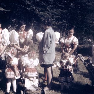 Group of women and children outdoors in traditional folk attire.