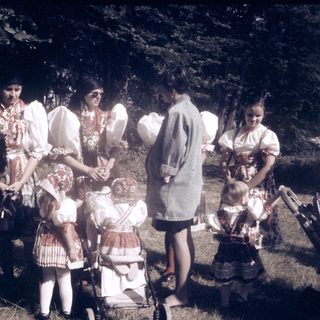 Group of women and children outdoors in traditional folk attire.