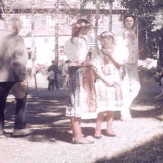 Large tree surrounded by people in outdoor setting.