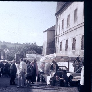 Vintage outdoor market with crowd and stalls.