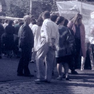 Vintage outdoor market with crowd and stalls.